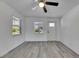 Bright living room with wood-look flooring, a ceiling fan, and natural light from multiple windows at 1940 N Betty Ln, Clearwater, FL 33755