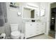 Well-lit bathroom with double vanity sinks, a large mirror, and a toilet, providing a clean design at 19651 Gulf Blvd # A11, Indian Shores, FL 33785