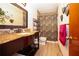 Stylish bathroom with a granite vanity, unique mirrors, and a tiled shower with a decorative curtain at 204 Amana Ave, Brandon, FL 33510