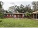 Inviting brick home with white trim, a covered carport, and a green lawn at 204 Amana Ave, Brandon, FL 33510