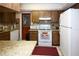 A view of the kitchen with white appliances, wood cabinetry, and granite countertops at 204 Amana Ave, Brandon, FL 33510