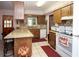 Cozy kitchen with a breakfast bar, granite countertops, mosaic backsplash, and wood cabinetry at 204 Amana Ave, Brandon, FL 33510