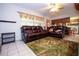 Comfortable living room featuring leather sofas, a ceiling fan, and access to the kitchen at 204 Amana Ave, Brandon, FL 33510