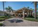 Elegant clubhouse entrance with covered portico, manicured landscaping, and inviting atmosphere at 2282 Sifield Greens Way # 54, Sun City Center, FL 33573