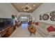 Open concept living room with tray ceiling, tile floors, and sliding glass doors to the lanai at 2282 Sifield Greens Way # 54, Sun City Center, FL 33573