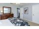 Neutral bedroom with a wooden dresser, mirror, and a glimpse into an en-suite bathroom through the open doorway at 2966 Eagle Estates W Cir, Clearwater, FL 33761