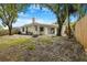 Backyard featuring a grassy area, trees, privacy fence, and covered patio at 3616 Cypress Meadows Rd, Tampa, FL 33624