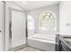 Bright bathroom featuring a shower, tub, and decorative block window at 3616 Cypress Meadows Rd, Tampa, FL 33624