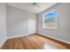 Bright bedroom features hardwood floors, white trim, ceiling fan and a large window offering natural light at 3616 Cypress Meadows Rd, Tampa, FL 33624