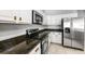 Modern kitchen with stainless steel appliances, white cabinets, and granite countertops, offering a sleek cooking space at 3616 Cypress Meadows Rd, Tampa, FL 33624