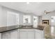 Open kitchen with granite countertops, stainless steel sink and appliances, seamlessly connecting to the living area with a fireplace at 3616 Cypress Meadows Rd, Tampa, FL 33624
