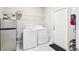 A well-lit laundry room equipped with a washer, dryer, storage shelf, and a compact refrigerator at 38152 Cobble Creek Blvd, Zephyrhills, FL 33540