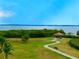 Breathtaking waterfront view with lush greenery, a walking path, and a quaint gazebo at 406 Shore W Dr, Oldsmar, FL 34677