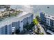 An aerial view of a condominium building with a waterway and boat docks in the background at 610 Island Way # 402, Clearwater Beach, FL 33767