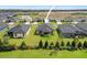 An aerial view of the backyard features a covered patio, and is surrounded by lush landscaping and a green lawn at 6127 164Th E Ave, Parrish, FL 34219