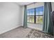 Empty bedroom features carpeted floors, a window with blinds and blue curtains at 6127 164Th E Ave, Parrish, FL 34219