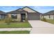 Charming single-story home featuring a well-maintained lawn and a two-car garage at 6127 164Th E Ave, Parrish, FL 34219