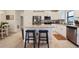 A kitchen features stainless steel appliances, white cabinets, a granite counter and an island with seating at 6127 164Th E Ave, Parrish, FL 34219