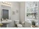 A well-lit half bathroom featuring a pedestal sink, neutral wall color and tiled flooring at 6134 Fishhawk Crossing Blvd, Lithia, FL 33547