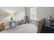 Bright bedroom features a rocking chair, small table and neutral color palette at 6134 Fishhawk Crossing Blvd, Lithia, FL 33547