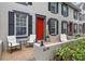 Charming townhome with a bright red door, black shutters, and a cozy front porch sitting area at 6134 Fishhawk Crossing Blvd, Lithia, FL 33547