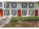 Townhome exterior with red door, black shutters and window trim with lush green foliage at 6134 Fishhawk Crossing Blvd, Lithia, FL 33547