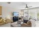 Comfortable living room with a ceiling fan, and a door leading to the fenced back patio at 6134 Fishhawk Crossing Blvd, Lithia, FL 33547