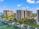 Stunning aerial view of waterfront condos, marina, and lush landscaping under a bright, partly cloudy sky at 690 Island Way # 1003, Clearwater Beach, FL 33767