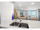 Bright kitchen with granite countertops, stainless sink, and view to a dining area and outdoor balcony beyond at 690 Island Way # 1003, Clearwater Beach, FL 33767