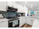 Updated kitchen featuring white cabinets, stone countertops, and a colorful backsplash at 690 Island Way # 1003, Clearwater Beach, FL 33767