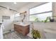 Bright bathroom with a marble-top vanity, modern sink, and patterned tile flooring next to the walk-in shower at 806 E New Orleans Ave, Tampa, FL 33603