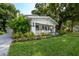 Inviting craftsman-style bungalow with lush landscaping, manicured lawn, and a quaint covered porch at 806 E New Orleans Ave, Tampa, FL 33603