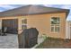 Backyard patio featuring a grill, outdoor seating, and well-maintained landscaping at 8949 Southern Charm Cir, Brooksville, FL 34613