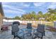 Backyard with a patio set, grill, and white picket fence overlooking green space at 8949 Southern Charm Cir, Brooksville, FL 34613