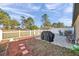 Outdoor patio with a grill, seating and a white privacy fence on a sunny day at 8949 Southern Charm Cir, Brooksville, FL 34613