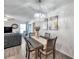 A dining room with hardwood floors, gray furniture and a modern chandelier adds a contemporary touch to the space at 8949 Southern Charm Cir, Brooksville, FL 34613
