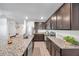 Modern kitchen featuring stainless steel appliances, granite countertops, and dark wood cabinetry at 8949 Southern Charm Cir, Brooksville, FL 34613