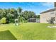 Lush backyard features a playset, screened-in patio, and ample green space surrounded by mature trees at 9010 Grand Bayou Ct, Tampa, FL 33635