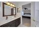 Bathroom featuring a double sink vanity, a large mirror, and a doorway into the bedroom at 9010 Grand Bayou Ct, Tampa, FL 33635