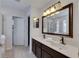 Bathroom featuring a double sink vanity, a large mirror, and a separate room for the toilet at 9010 Grand Bayou Ct, Tampa, FL 33635