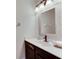 Bathroom featuring a single sink vanity with a dark wood cabinet, complemented by a framed mirror and modern fixtures at 9010 Grand Bayou Ct, Tampa, FL 33635