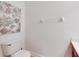 A minimalistic half bathroom includes a toilet, small vanity, and decorative floral wall art at 9010 Grand Bayou Ct, Tampa, FL 33635