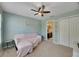 Light-filled bedroom featuring a ceiling fan, neutral carpet, and an ensuite bathroom at 9010 Grand Bayou Ct, Tampa, FL 33635