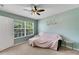 Bright bedroom with a ceiling fan, window with blinds, and light-colored carpet at 9010 Grand Bayou Ct, Tampa, FL 33635