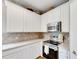 Kitchen area showcases white cabinets, stainless steel appliances, and neutral backsplash, complemented by a stainless steel microwave at 9010 Grand Bayou Ct, Tampa, FL 33635