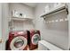Laundry room featuring modern washer and dryer, shelving for laundry products, and a hanging rack for clothes at 9010 Grand Bayou Ct, Tampa, FL 33635