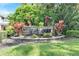 Welcome to River Chase, shown by sign with vibrant plants, and a landscaped community entrance at 9010 Grand Bayou Ct, Tampa, FL 33635