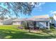 Lush backyard featuring a well-maintained lawn, mature trees and a screened in patio at 9376 French Quarters Cir, Weeki Wachee, FL 34613