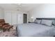 Well-lit bedroom features a ceiling fan, gray bedding, neutral walls, and plush brown chair at 9376 French Quarters Cir, Weeki Wachee, FL 34613