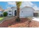Inviting single-story home showcasing a well-kept yard, mature palm tree, and a two-car garage at 9376 French Quarters Cir, Weeki Wachee, FL 34613
